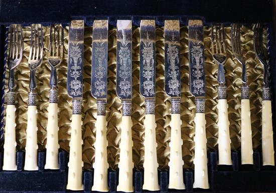 A case of twelve pairs of carved ivory handled silver plated dessert eaters.